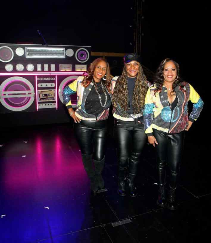 LAS VEGAS, NEVADA - AUGUST 31: (L-R) Rappers Michelle "Sassy C" Franklin, Juana "MC J.B." Burns and Dania "Baby D" Birks of J.J. Fad pose on stage after the premiere of "Boombox! A Vegas Residency on Shuffle" at Westgate Las Vegas Resort & Casino on August 31, 2022 in Las Vegas, Nevada.