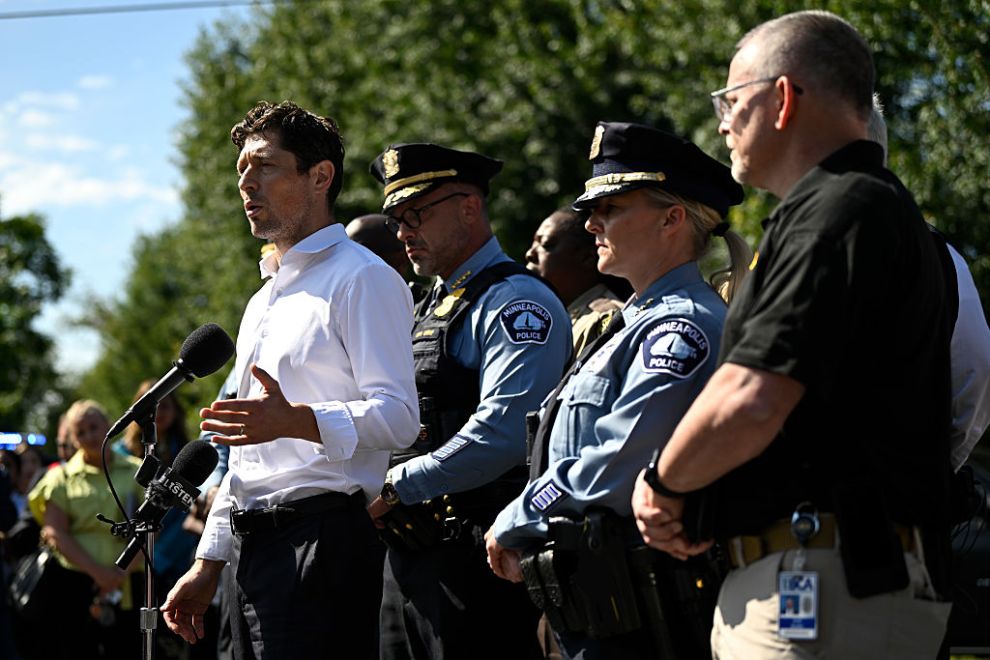 Minneapolis Mayor Jacob Frey (L) speaks to the media following a mass shooting at Annunciation Catholic Church on August 27, 2025 in Minneapolis, Minnesota. According to Minneapolis Police, a gunman fired through the windows of the church at worshippers sitting in pews during a Catholic school Mass, killing two children and injuring at least 17 others. The gunman reportedly died at the scene from a self-inflicted gunshot wound.